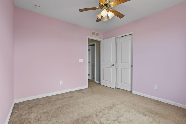 unfurnished bedroom with light colored carpet, ceiling fan, and a closet