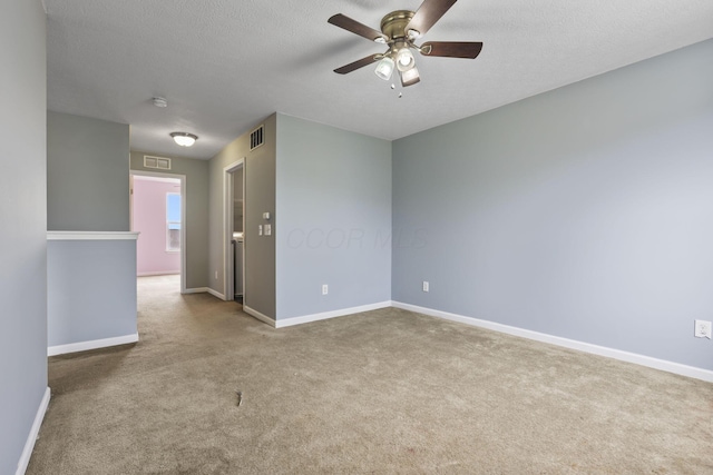 carpeted empty room with ceiling fan and a textured ceiling