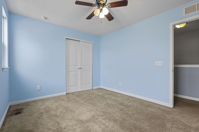 unfurnished bedroom with light carpet, a closet, and ceiling fan