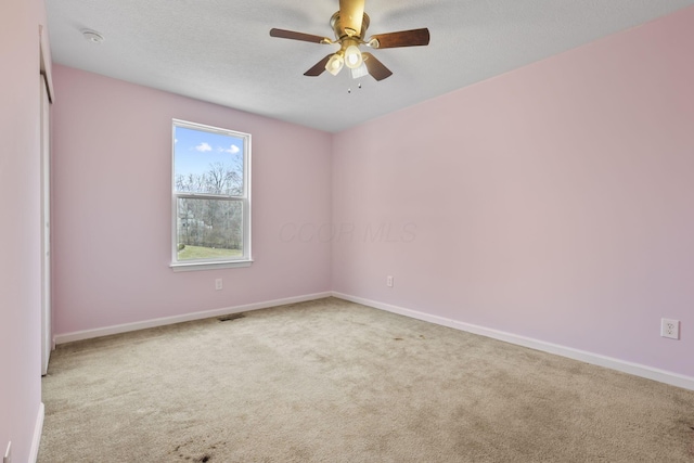 carpeted empty room with ceiling fan and a textured ceiling