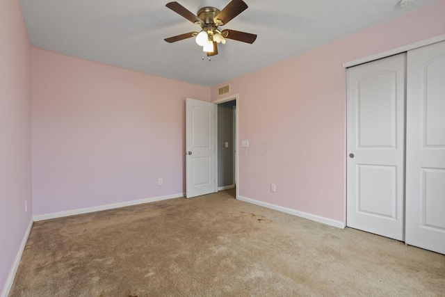 unfurnished bedroom featuring light carpet, ceiling fan, and a closet