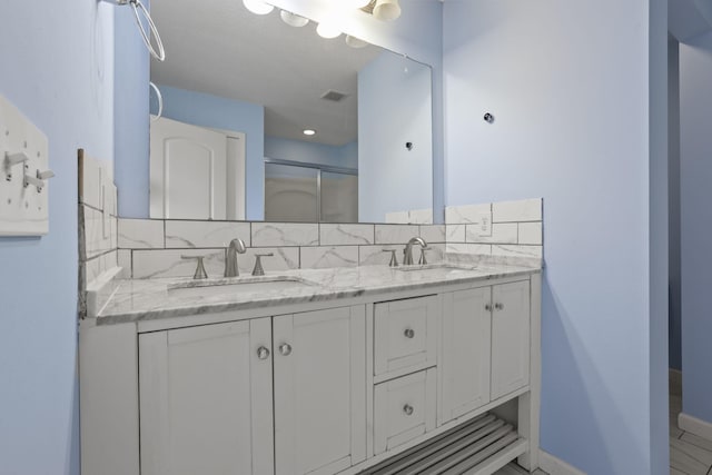 bathroom featuring vanity, backsplash, and walk in shower