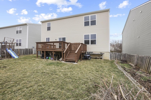 back of property featuring a playground, a wooden deck, and a yard