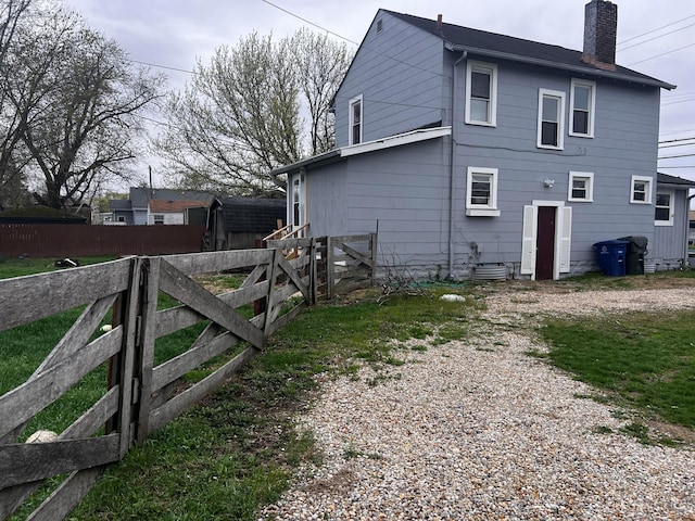 1146 Brentnell Ave, Columbus, OH 43219 - view of home's exterior featuring a chimney, fence, and driveway