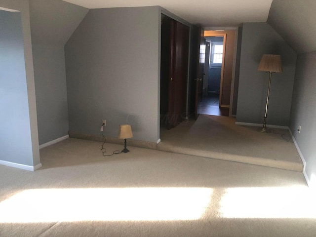 bonus room with vaulted ceiling and carpet