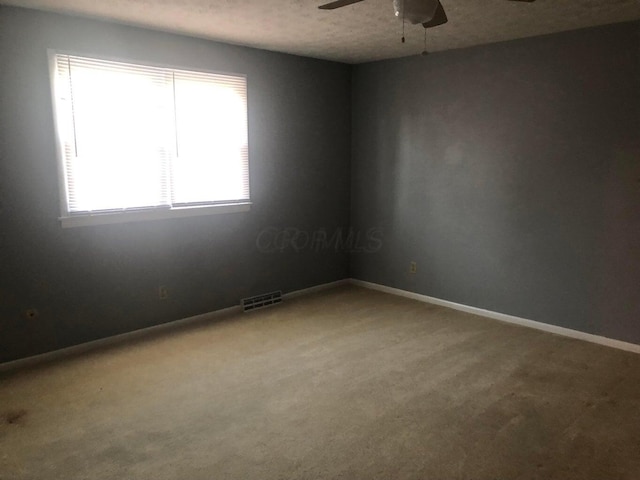 unfurnished room with carpet flooring, a textured ceiling, and ceiling fan