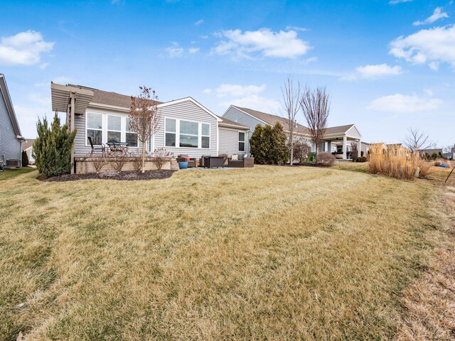 back of house featuring a lawn, a patio area, and an outdoor living space