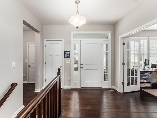 foyer featuring baseboards and dark wood finished floors