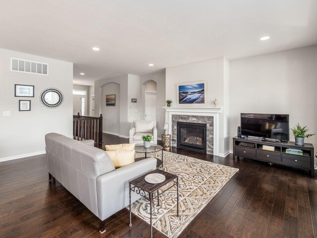 living area with wood-type flooring, visible vents, and baseboards