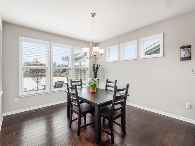 dining space with dark wood-type flooring, visible vents, and baseboards