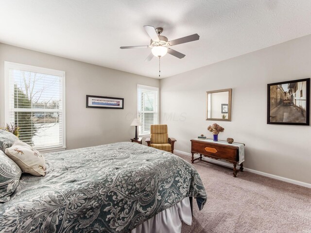 carpeted bedroom with ceiling fan and baseboards