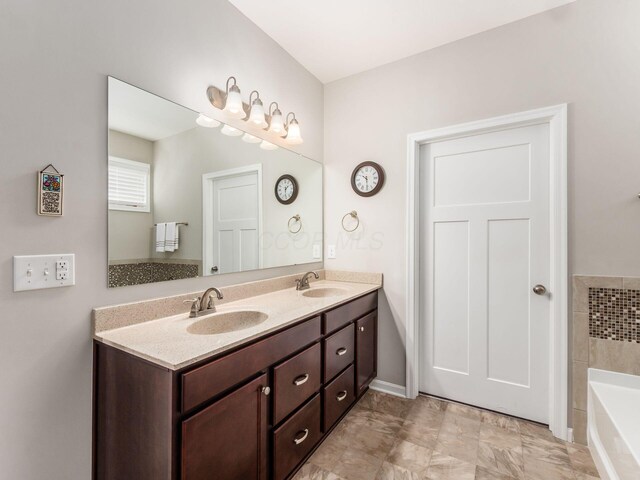 bathroom featuring double vanity, a sink, and a tub