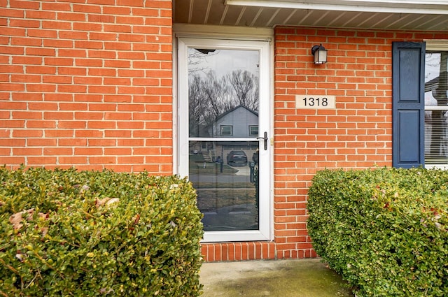 view of exterior entry featuring brick siding