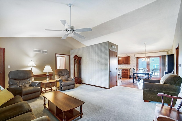 living room with lofted ceiling, light colored carpet, ceiling fan with notable chandelier, visible vents, and wallpapered walls