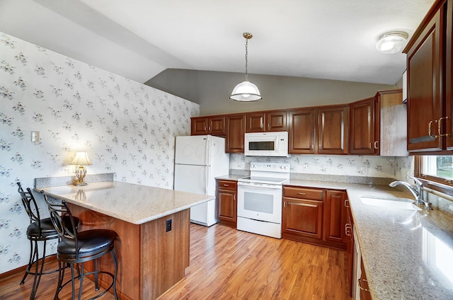 kitchen with pendant lighting, light wood-style flooring, a sink, white appliances, and wallpapered walls