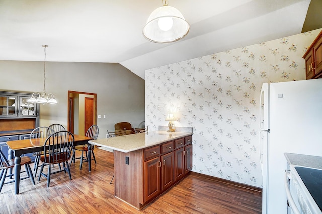 kitchen with a peninsula, vaulted ceiling, hanging light fixtures, light wood-type flooring, and wallpapered walls