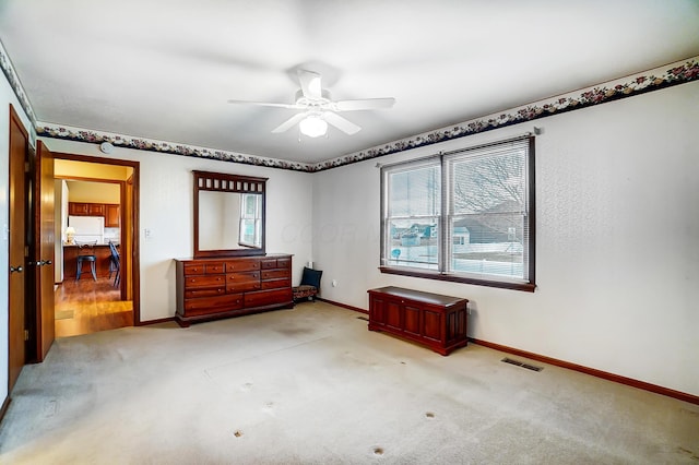 unfurnished room with light colored carpet, visible vents, ceiling fan, and baseboards