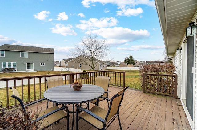 deck with a yard, outdoor dining area, and a residential view