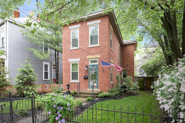 italianate house with brick siding, a fenced front yard, and a front yard