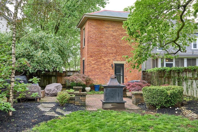 back of house with brick siding and fence