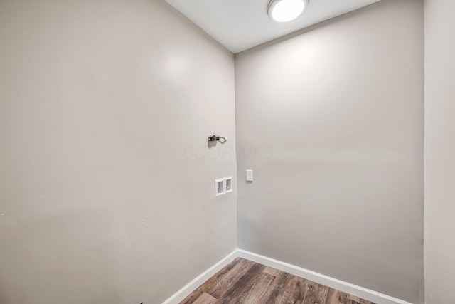 clothes washing area with wood-type flooring and hookup for a washing machine