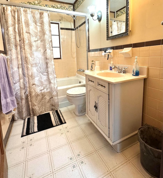 full bathroom with shower / bath combo, tile walls, vanity, and toilet