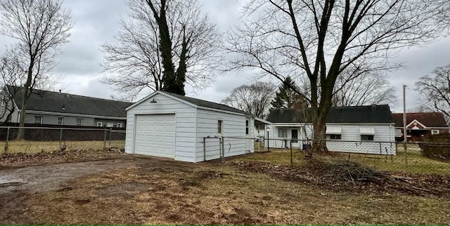 rear view of property featuring a garage and an outdoor structure