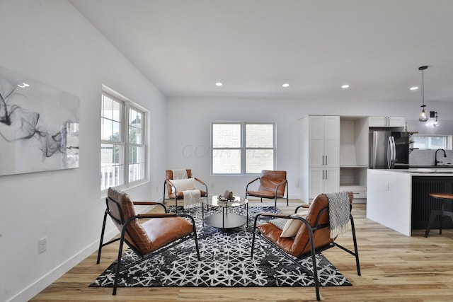 sitting room featuring sink, a wealth of natural light, and light wood-type flooring