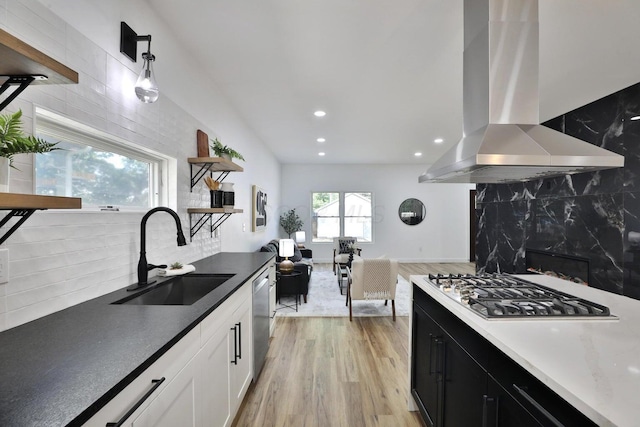 kitchen featuring sink, appliances with stainless steel finishes, hanging light fixtures, white cabinets, and island exhaust hood