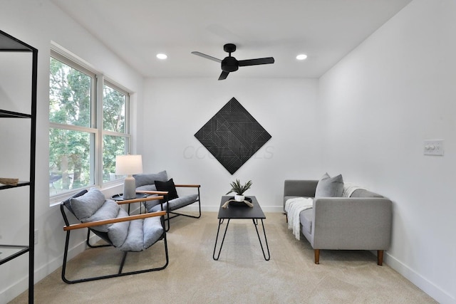 sitting room featuring light colored carpet and ceiling fan