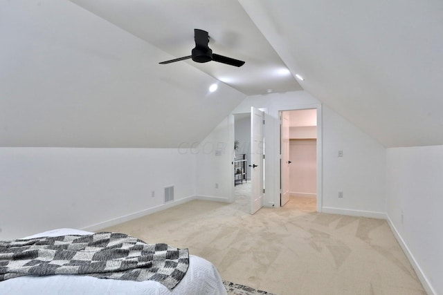 carpeted bedroom featuring lofted ceiling, a spacious closet, and ceiling fan