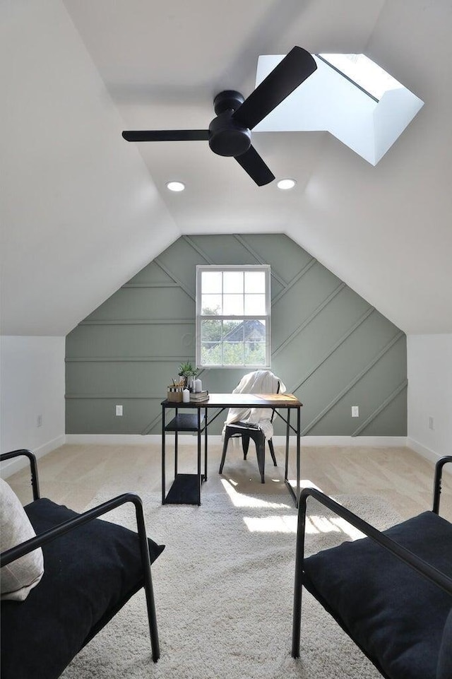 office space featuring vaulted ceiling, light carpet, and ceiling fan