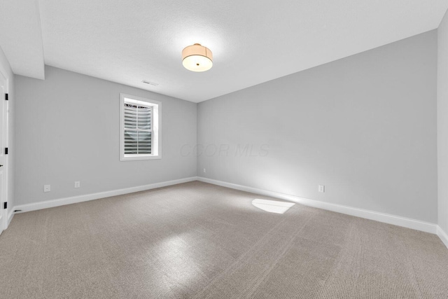 spare room with carpet and a textured ceiling