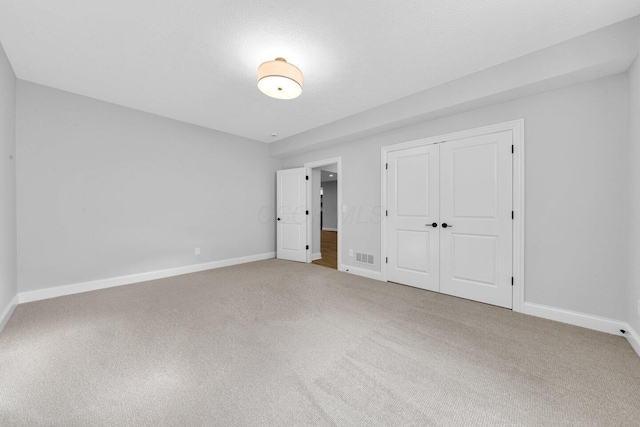 unfurnished bedroom with carpet, a textured ceiling, and a closet