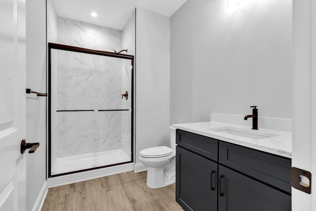 bathroom featuring hardwood / wood-style flooring, vanity, toilet, and walk in shower