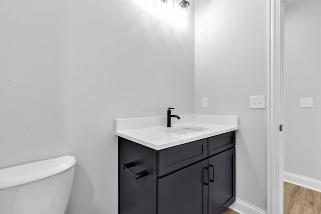 bathroom featuring hardwood / wood-style flooring, vanity, and toilet