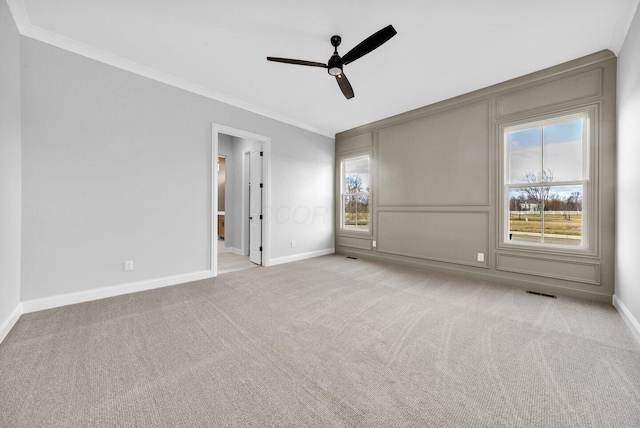 unfurnished room with ornamental molding, light colored carpet, and ceiling fan