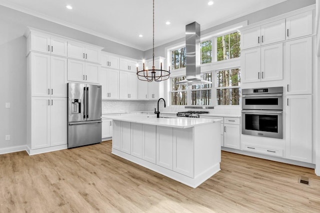 kitchen featuring decorative light fixtures, sink, white cabinets, island exhaust hood, and stainless steel appliances