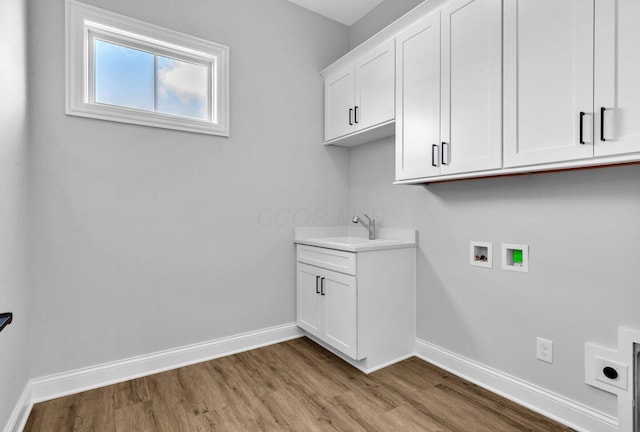 clothes washing area featuring sink, cabinets, hookup for a washing machine, hookup for an electric dryer, and light wood-type flooring