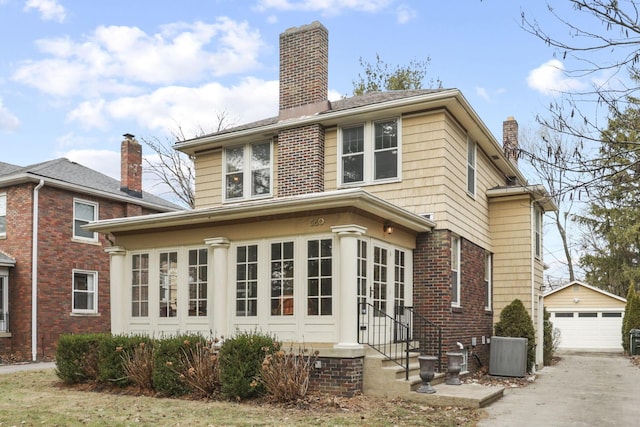 view of front of home with central AC, a garage, and an outdoor structure