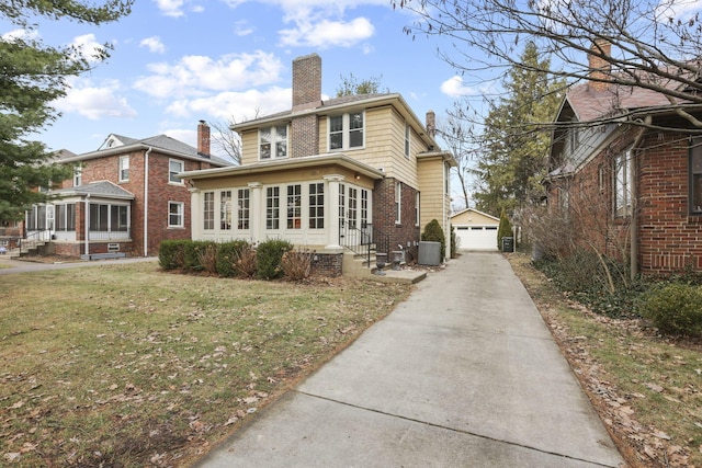 exterior space featuring an outbuilding, a yard, a garage, and central AC