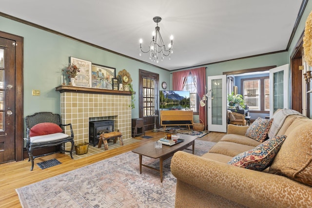 living room with wood-type flooring, ornamental molding, and a notable chandelier