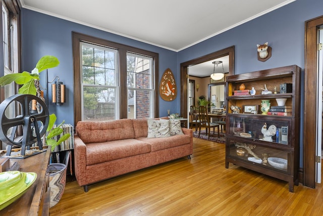 sitting room with ornamental molding and light hardwood / wood-style floors