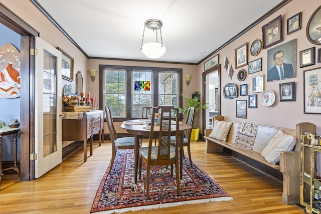 dining space with crown molding and light hardwood / wood-style flooring