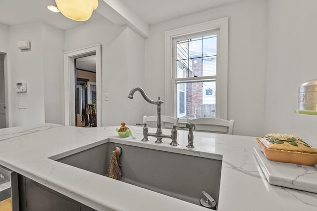 kitchen featuring light stone countertops and sink