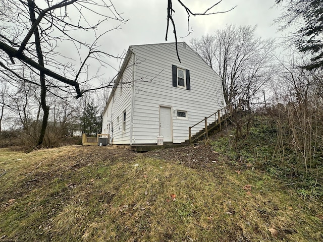 view of home's exterior featuring central AC unit and a lawn