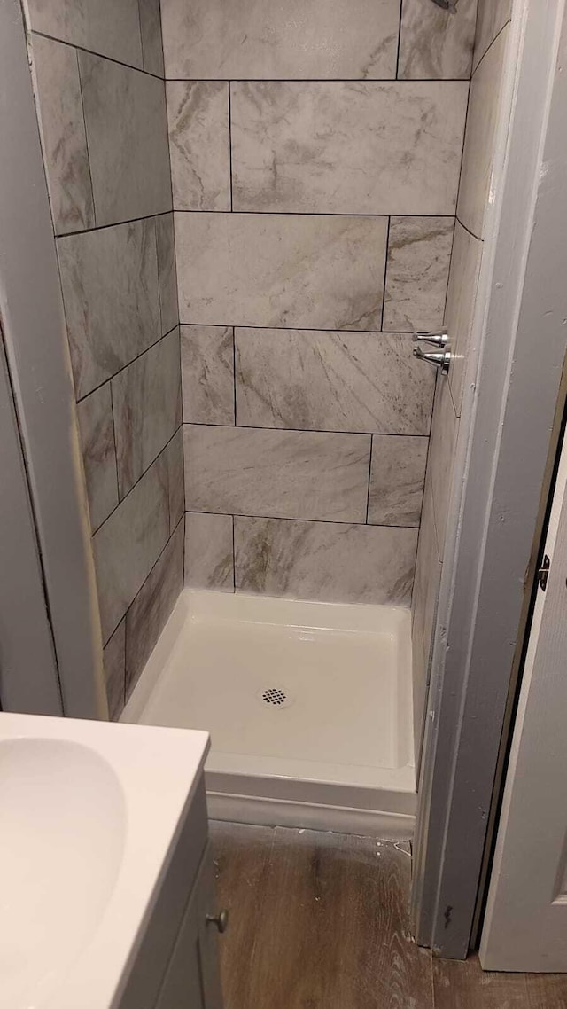 bathroom featuring a tile shower and vanity