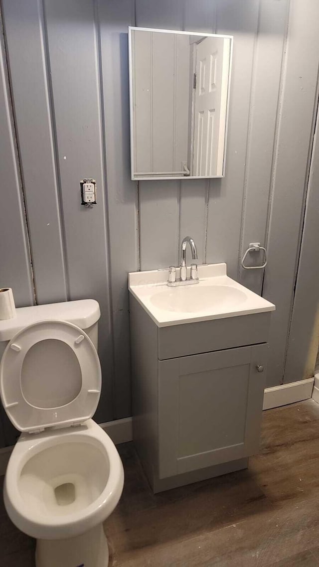 bathroom with hardwood / wood-style flooring, vanity, and toilet