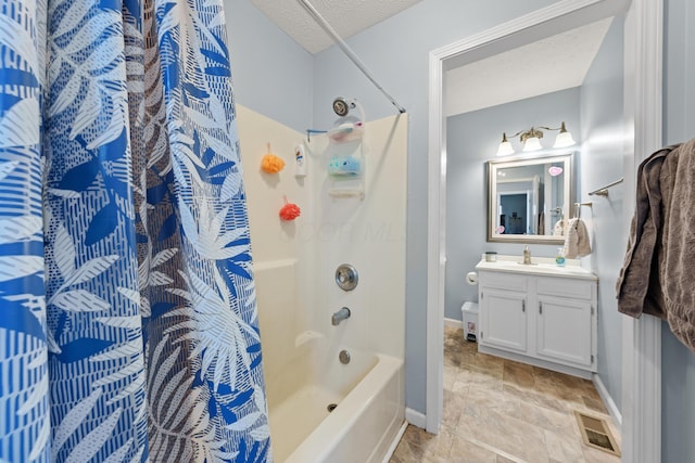 bathroom with shower / tub combo with curtain, vanity, and a textured ceiling