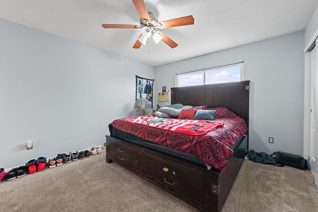 carpeted bedroom with ceiling fan and a textured ceiling